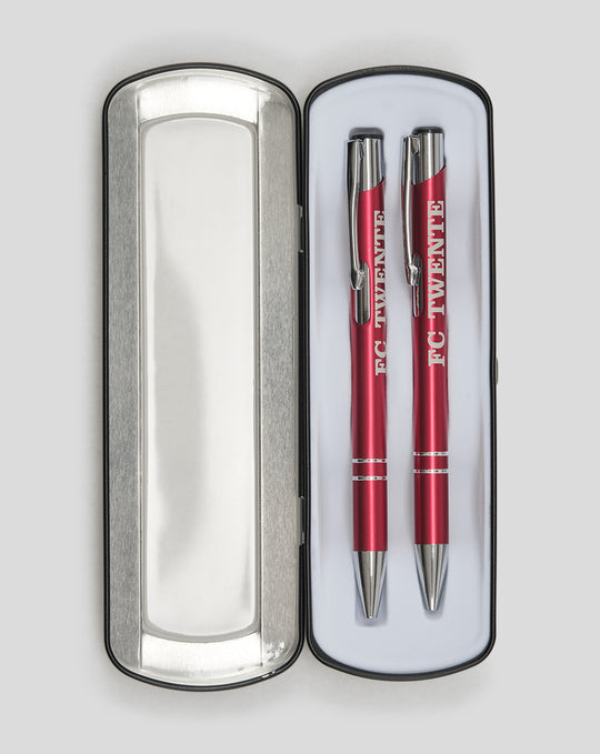 Two red FC Twente pens in an open silver metal tin with white lining