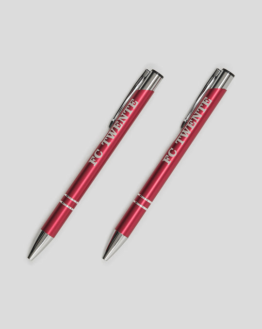 Two red FC Twente pens lying diagonally on a light gray background