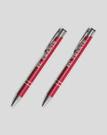 Two red FC Twente pens lying diagonally on a light gray background