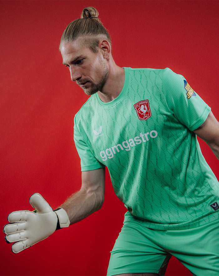 Action shot of a goalkeeper wearing the green FC Twente Keepershirt 25/26 showing the fit and crest.