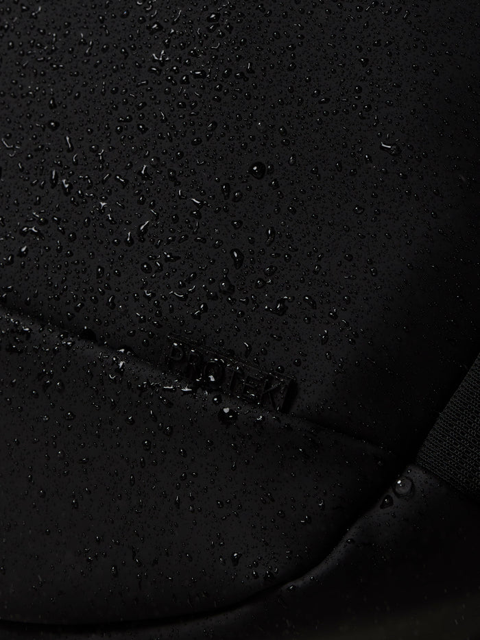 Close-up of gunmetal Castore Core Backpack fabric with scattered water droplets.