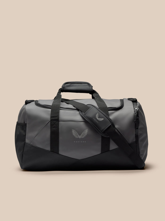 Full view of gunmetal gray Core Holdall Tas with black straps and reflective logo