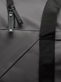 Close-up of gunmetal Core Holdall zipper and strap on dark PU exterior.