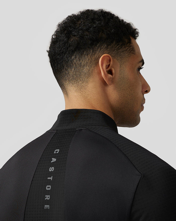Back shoulder view of black Castore Apex Aeromesh top showing a vertical CASTORE branding stripe.