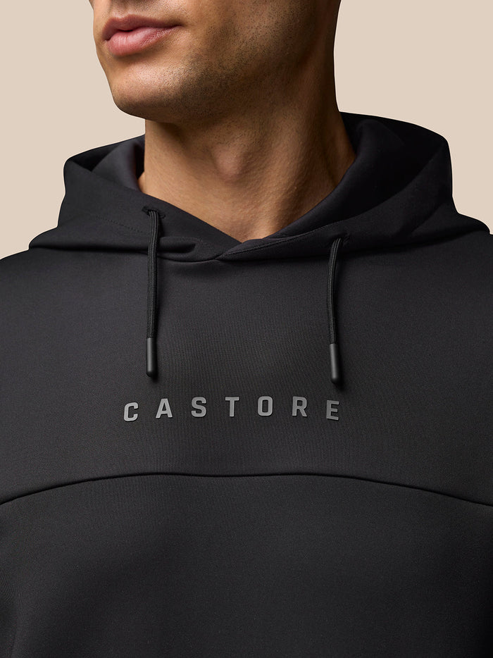 Close-up of a black hooded sweatshirt with drawstrings and CASTORE across the chest.