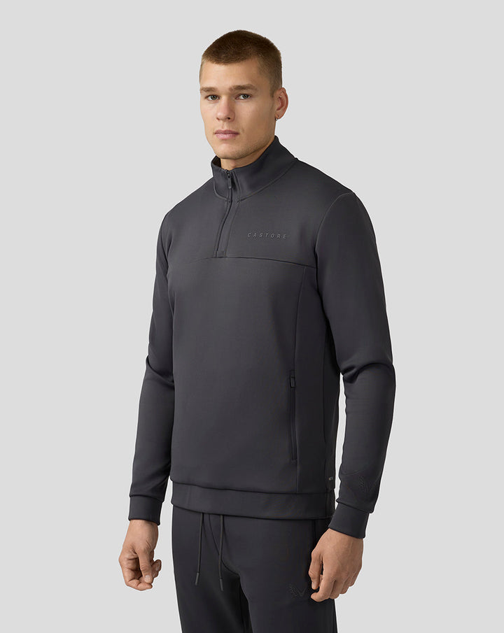 Man in charcoal Scuba Quarter Zip Top met rits en zakken Castore-logo op borst