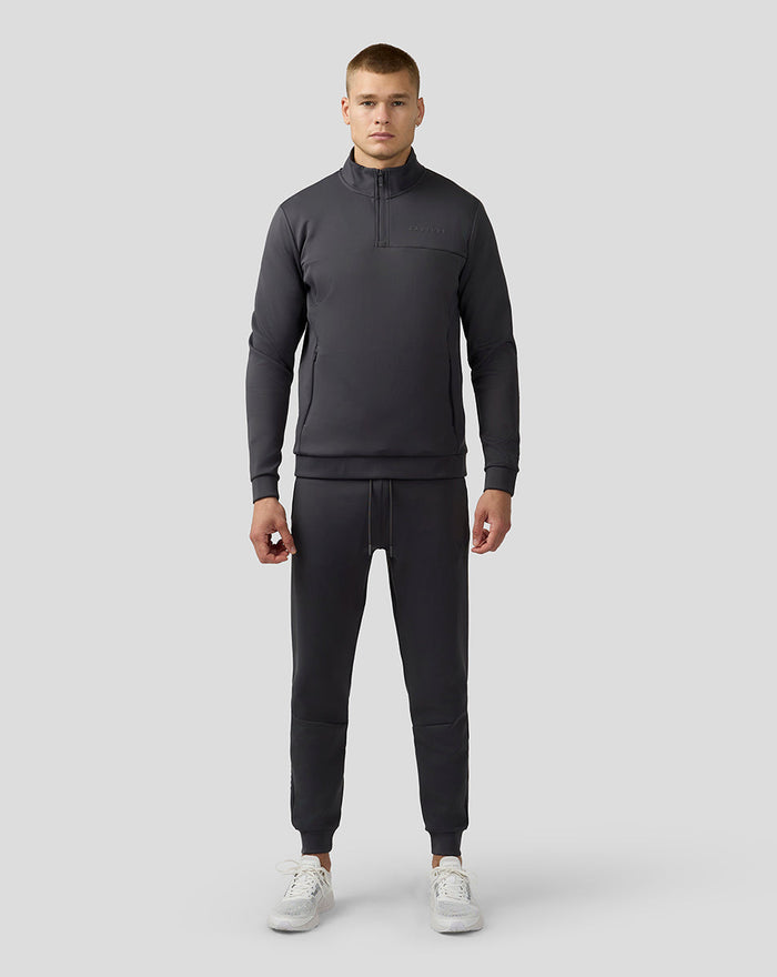Front view of a man wearing the charcoal Scuba top with a quarter zip and zip pockets.