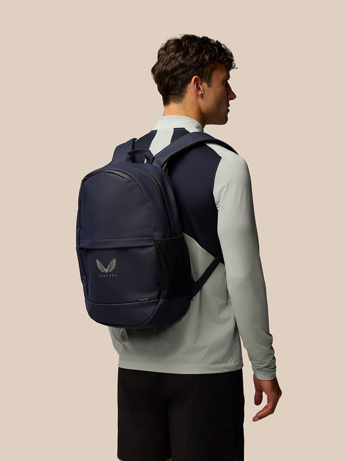 Model wearing navy Active Backpack on back with Castore logo visible on front pocket