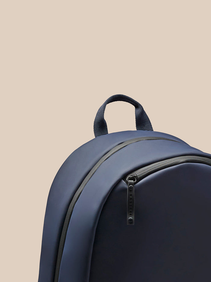Partial close up of the Active Backpack Navy zipper pocket with a Castore branded zipper pull.