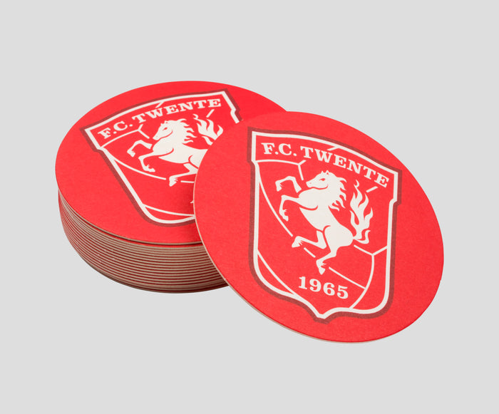 Close up of FC Twente red beer coasters featuring crest