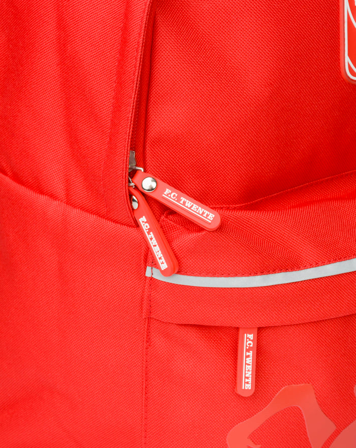 Front zipper area of red FC Twente backpack with branded pulls and reflective trim.