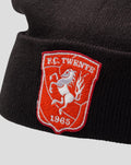 Detail van zwarte kinder muts met rode FC Twente badge geborduurd op de omslag