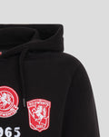 Lower front of black FC Twente hoodie with large white FC TWENTE text and embroidered patches along the chest