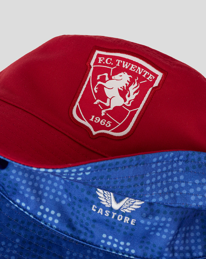 Close-up of red FC Twente bucket hat showing embroidered crest patch on the front with 1965