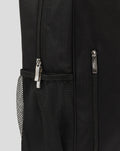 Close up of black fabric backpack showing a zipper and metal pull tab beside a mesh side pocket