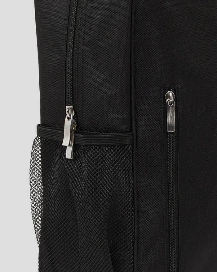 Close up of black fabric backpack showing a zipper and metal pull tab beside a mesh side pocket