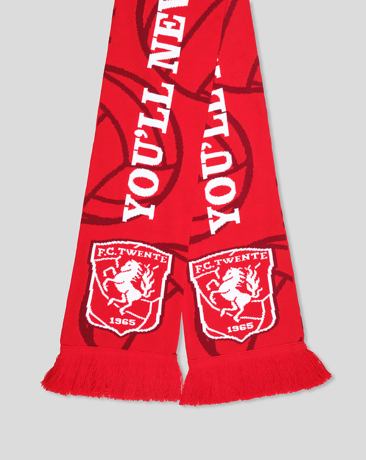 Close-up of red FC Twente scarf fringe with white crests and YOU'LL NEVER WALK ALONE text visible