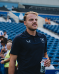 Man in navy FC Twente travel polo at stadium with crest on the chest