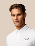 Front view of a man wearing a white Golf Pinnacle Pique Stripe Polo with a pointed collar and Castore logo on the chest