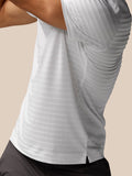 Close up of the side of a white Golf Pinnacle Pique Stripe Polo showing textured stripes and a side hem vent
