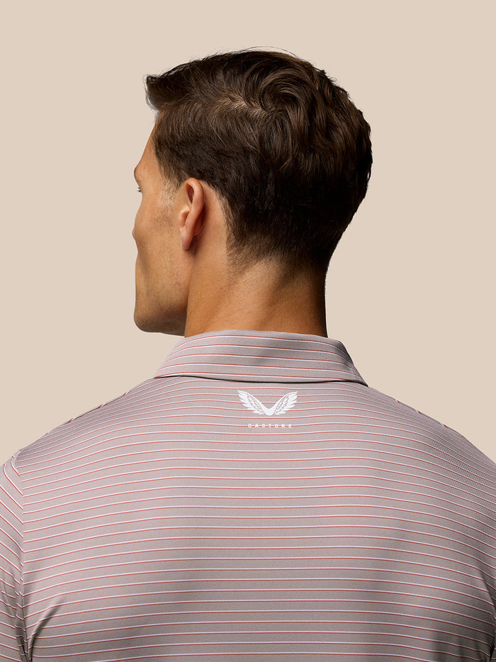 Back view of pink yarn-dye striped polo shirt with Castore logo on the upper back and Aertek branding on the lower back