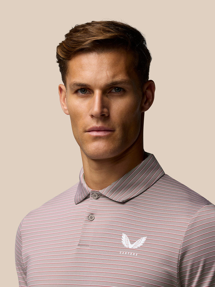 Front view of a pink yarn-dye striped polo shirt with four-way stretch and a Castore logo on the left chest