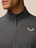 Close-up of gunmetal golf top showing front zipper and stand collar with Castore branding on the chest.