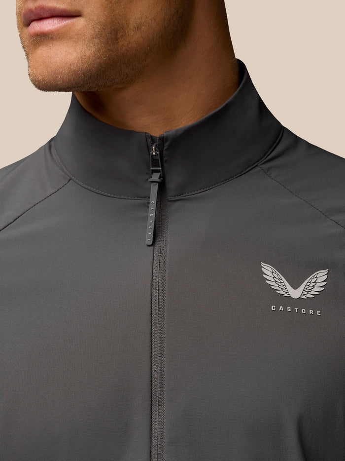 Close-up of gunmetal golf top showing front zipper and stand collar with Castore branding on the chest.
