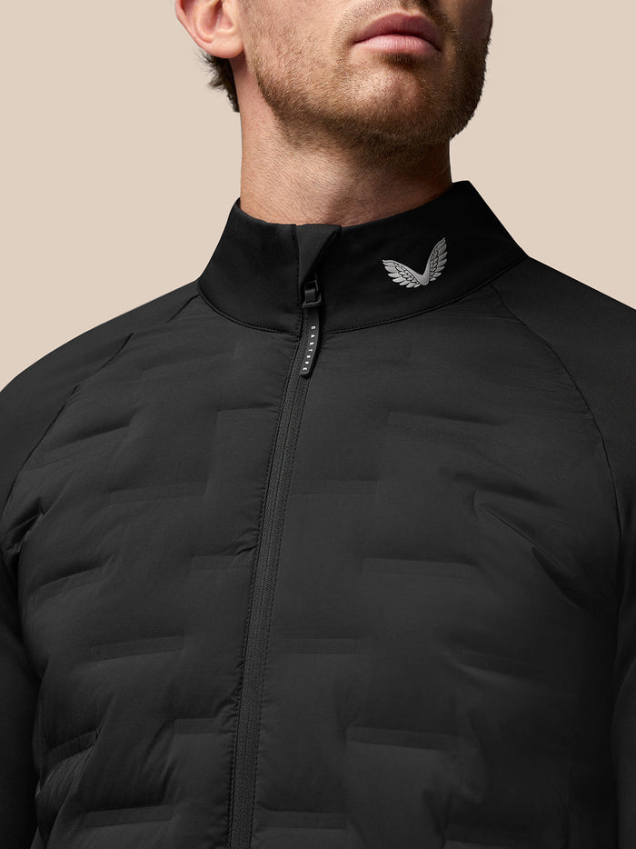 Front close-up of black Pinnacle Hybrid golf jacket with full-length zipper and wing logo on the collar.