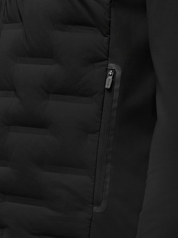 Close up of a zip pocket on the black Pinnacle hybrid quilted golf jacket showing quilting and a CASTORE zipper pull