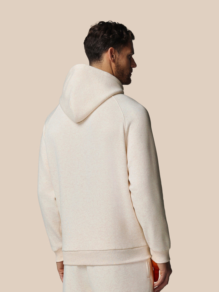 Back view of a man in an oatmeal fleece hoodie with hood up highlighting relaxed fit and soft fabric