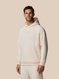Male model wearing oatmeal cotton fleece hoodie with Castore logo on chest and zip pocket