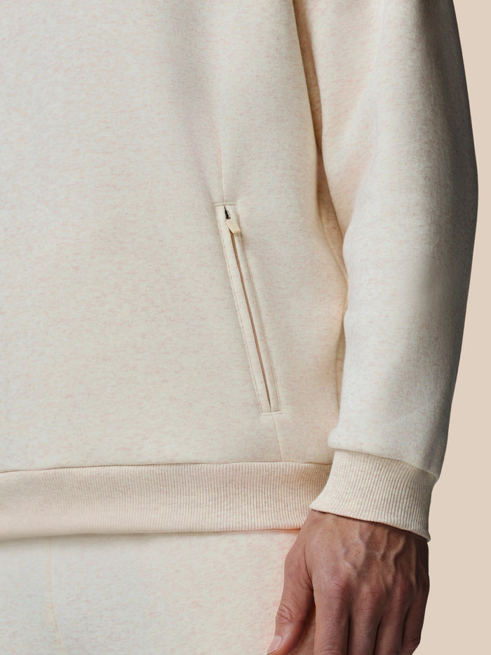 Close up of oatmeal marl fleece hoodie fabric with a small side zip pocket