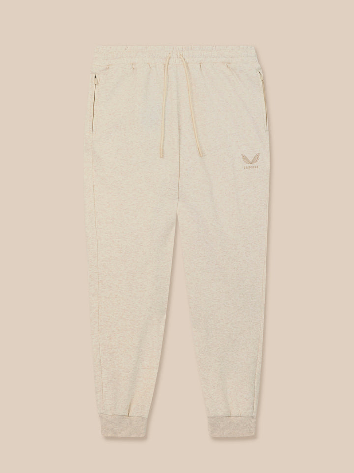 Front view of beige fleece joggers with drawstring waist and ribbed cuffs, featuring an embroidered Castore logo on the left thigh.