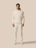 Full length model wearing beige fleece tracksuit hoodie and joggers with Castore logo on chest