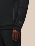 Close up of black Castore Flex hoodie sleeve showing a side zip and the Castore wing logo on the wrist.