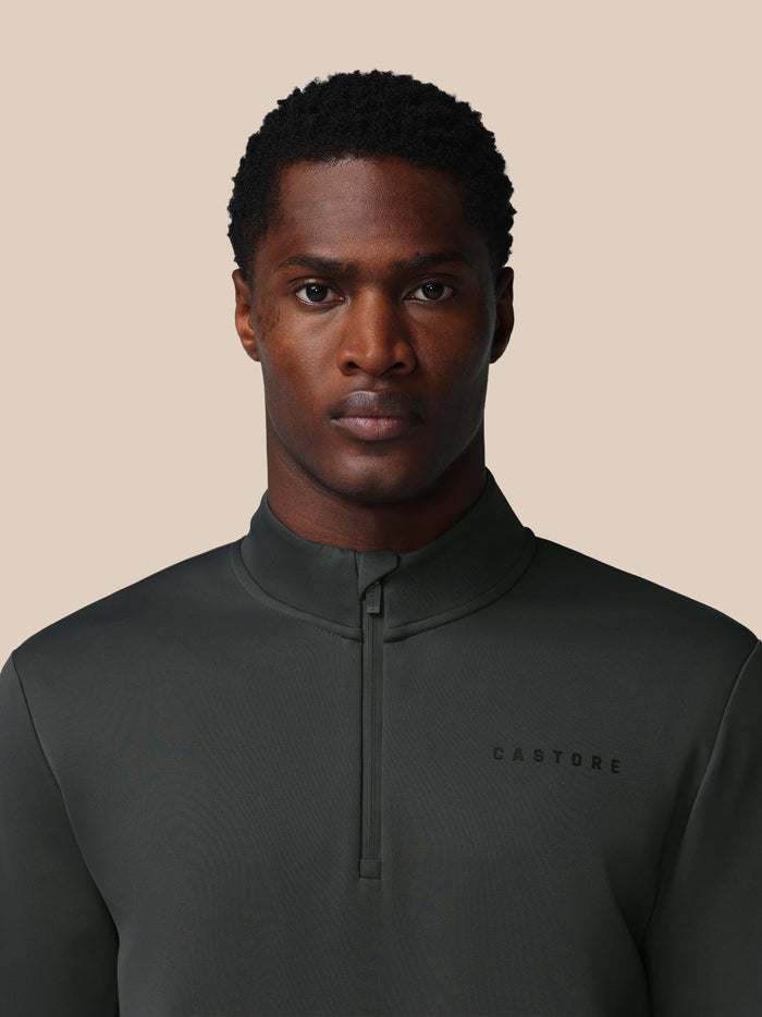 Nauwkeurige close-up van hals en borst van het gunmetal Heren Flex Sweatshirt met kwart-ritssluiting en Castore-logo op de borst