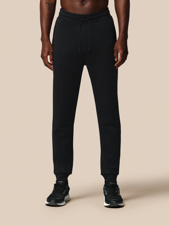 Full length shot of black Heren Flex Joggers worn by a model with sneakers.