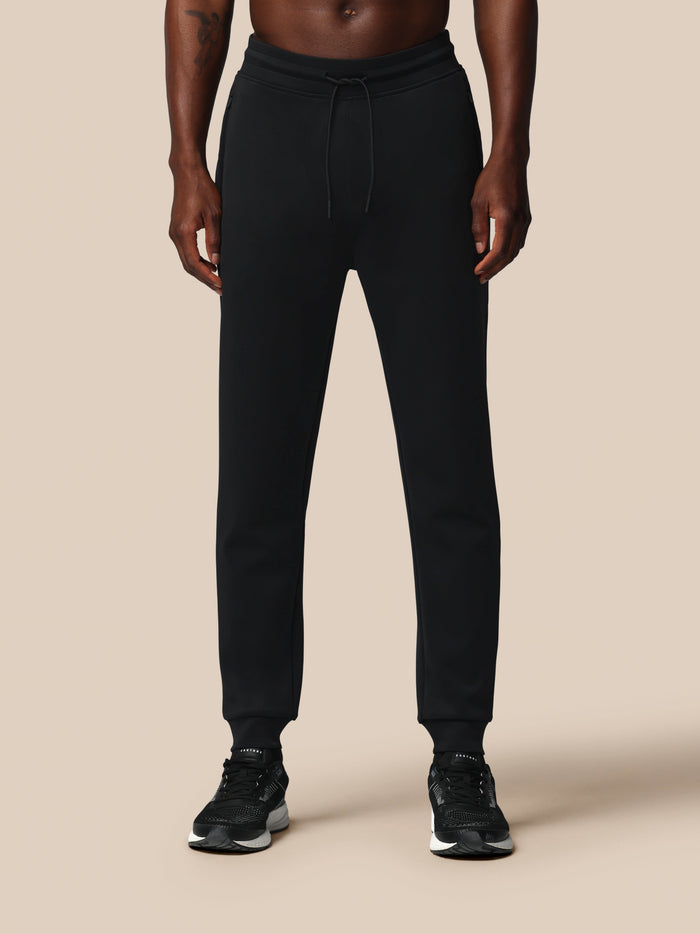 Full length shot of black Heren Flex Joggers worn by a model with sneakers.