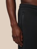 Close-up of a vertical side zipper pocket on the black Flex Joggers showing texture and stitching