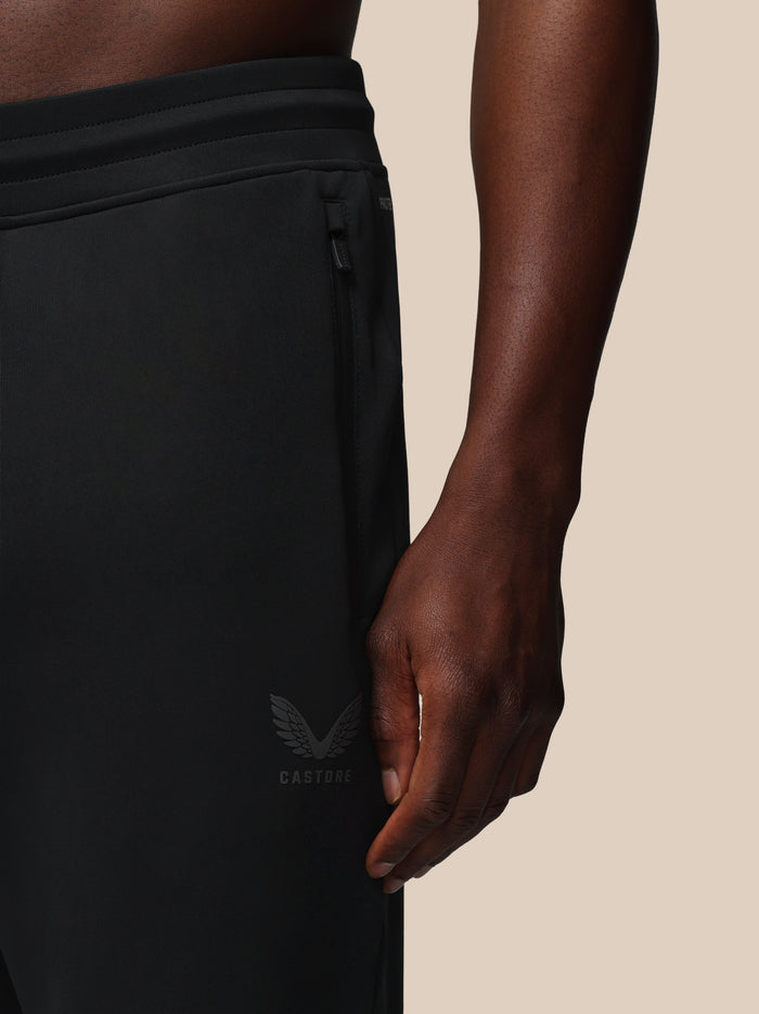 Close-up of black Heren Flex Joggers showing elastic waistband, side zip pocket and Castore logo on the thigh