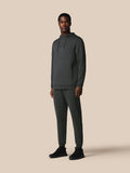 Male model wearing a dark green hoodie and matching joggers, full body product shot