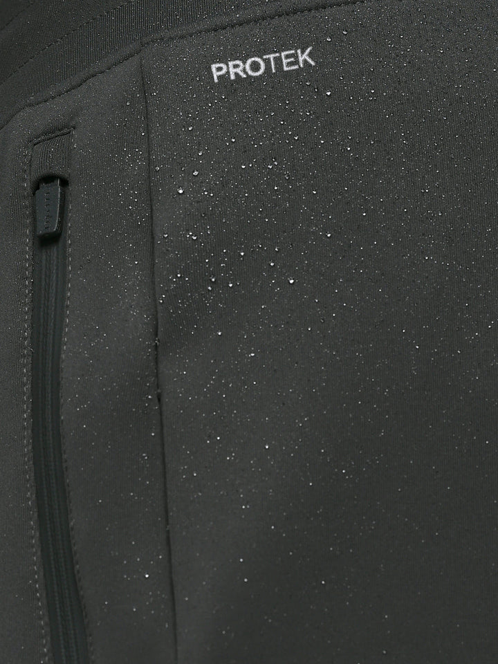 Close up of ProTek label on Gunmetal Heren Flex Joggers fabric showing waterproof detail and a zip pocket.