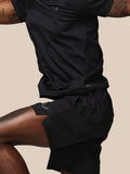 Side view of a male model wearing black Adapt Training Shorts with waistband branding visible