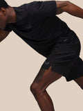 Male model in black Castore Adapt training shorts during workout showing jacquard waistband and left leg branding.