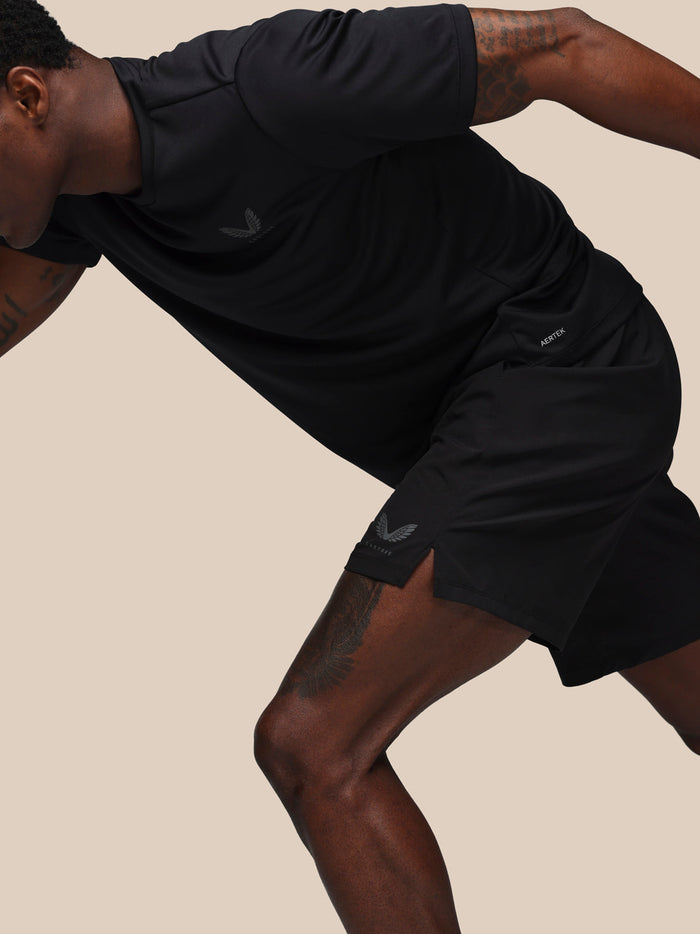 Male model in black Castore Adapt training shorts during workout showing jacquard waistband and left leg branding.