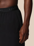 Close up of black Castore Adapt shorts waistband with PROTEK branding and water droplets on fabric.