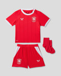 Baby FC Twente home shirt 26/27 red with white collar and crest, paired with matching shorts.