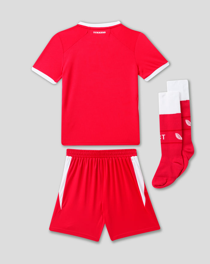 Achterkant van FC Twente thuisshirt voor kinderen in fel rood met witte kraag en boorden naast witrode sokken.