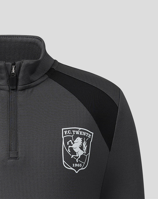 Close-up of FC Twente crest on chest of gunmetal midlayer top with zipper collar.